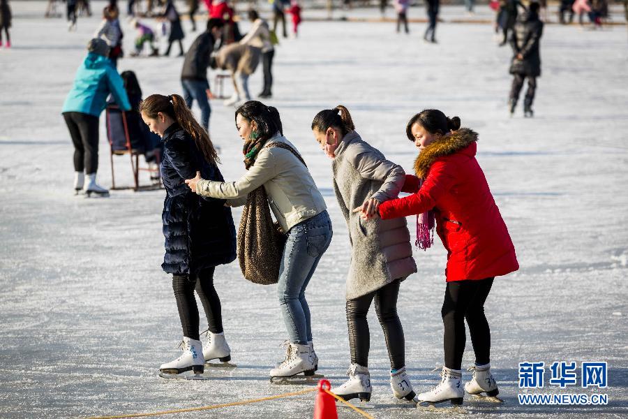 Радостные туристы на катке озера Хоухай в Пекине
