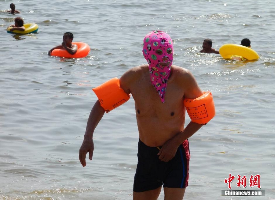 25 февраля, на пляже г. Санья немало туристов, плавающих в полном снаряжении. На лицах отдыхающих маски для защиты от солнечного ожога, получившие в Интернете название «фейскини» (Facekini).