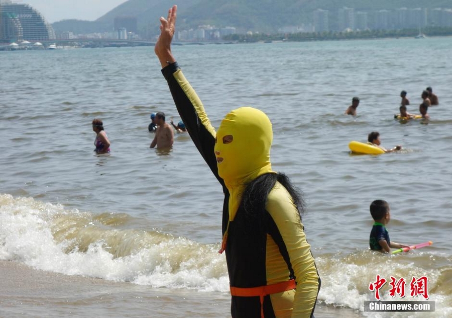 25 февраля, на пляже г. Санья немало туристов, плавающих в полном снаряжении. На лицах отдыхающих маски для защиты от солнечного ожога, получившие в Интернете название «фейскини» (Facekini).