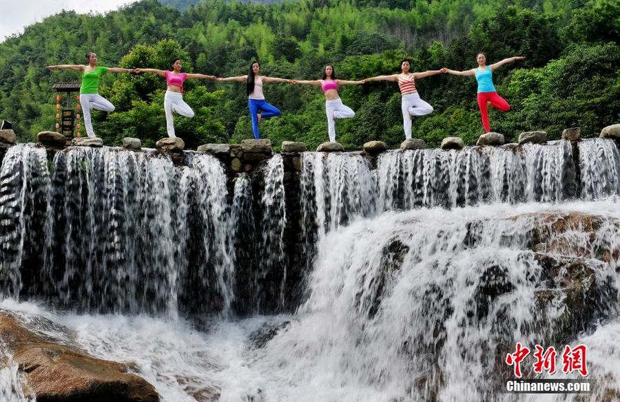 Китайские любители йоги демонстрируют асаны на фоне водопада Волунгу