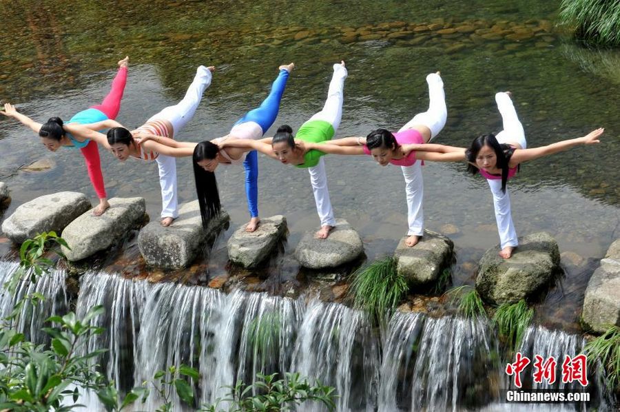Китайские любители йоги демонстрируют асаны на фоне водопада Волунгу