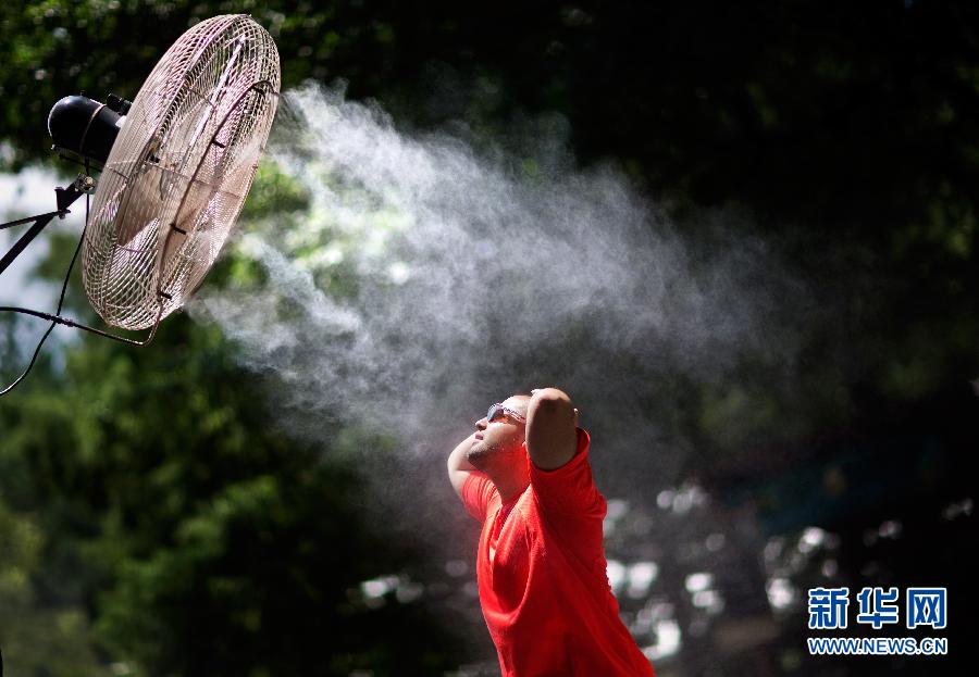 15 июля в зоопарке Атланты, мужчина наслаждался прохладой, принесенной охлаждающим вентилятором спреем.