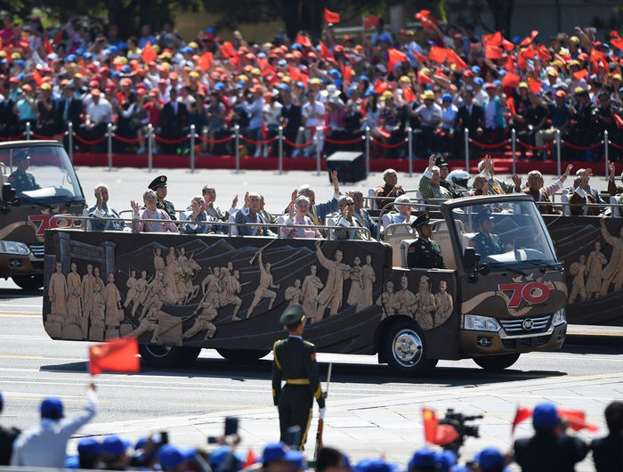 Через площадь Тяньаньмэнь проезжает строй ветеранов войны