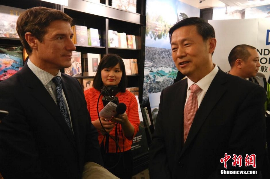 На фото: Заместитель начальника пресс-канцелярии Госсовета КНР Го Вэйминь (справа) ознакомил гостей с информацией о книжном фестивале.