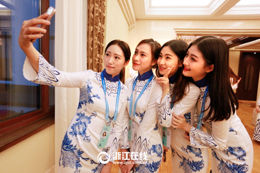 Вторая Всемирная конференция по управлению Интернетом: студентки-волонтеры одеты в ципао с узором под китайский фарфор