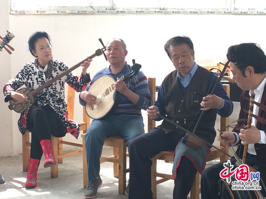 Тетушка Сюй (первая слева) участвует в мероприятии актеров-любителей в Пекине, она аккомпанирует на саньсяне своим коллегам по труппе.