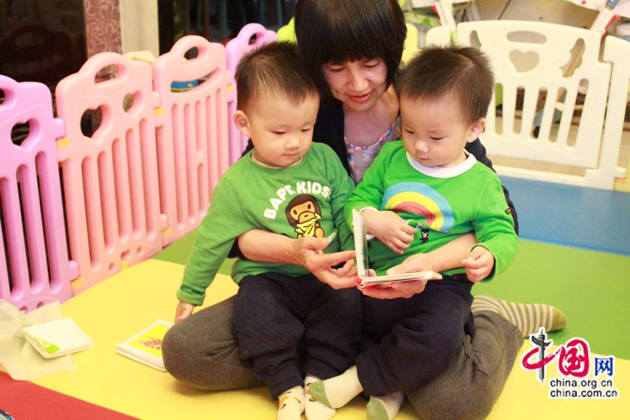 Хань Синьай читает книгу двум своим внукам.