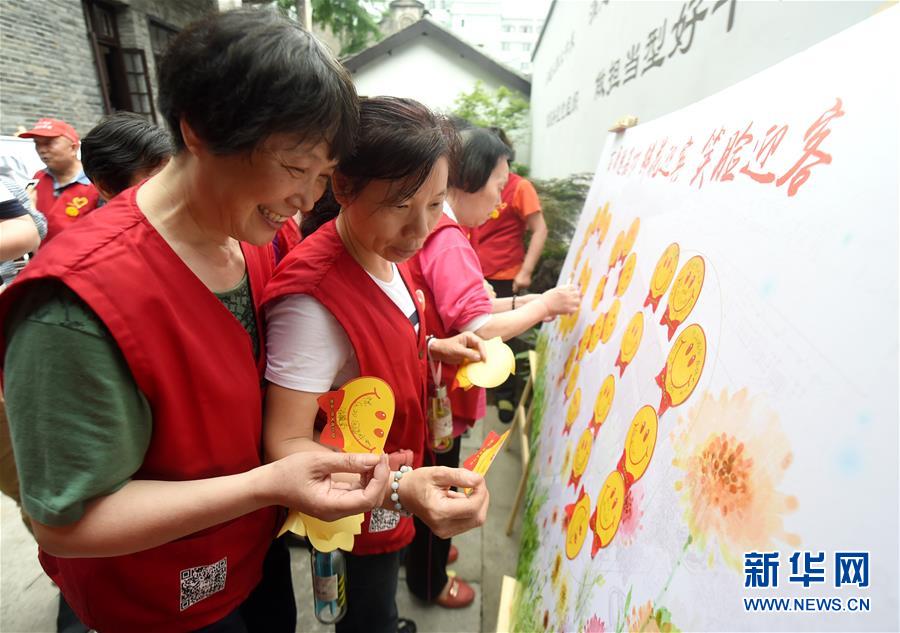 25 мая, в рамках инициативы «С улыбкой встретим гостей» жители Ханчжоу приклеивают на плакат улыбающиеся стикеры, готовясь в сентябре этого года принимать участников саммита G20.