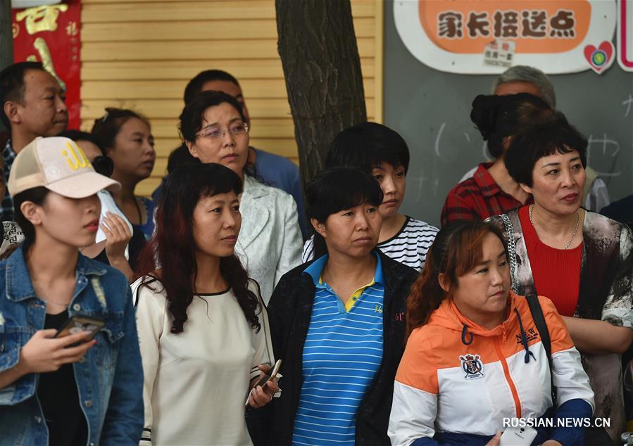 Во вторник в Китае начались общенациональные вступительные экзамены в вузы -- 2016, участие в которых принимают 9,4 млн абитуриентов. На фото -- родные вчерашних школьников в тревожном ожидании новостей.