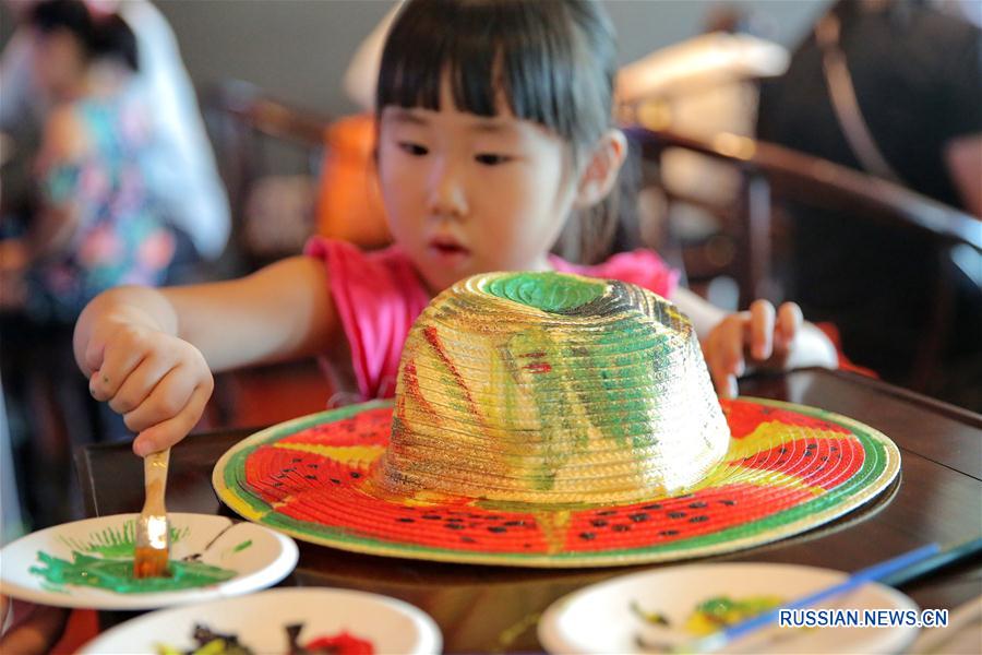  Юные жители Цзясина /провинция Чжэцзян, Восточный Китай/ сегодня в сопровождении родителей пришли в местный музей, чтобы принять участие в социальной акции по летнему раскрашиванию соломенных шляпок. 