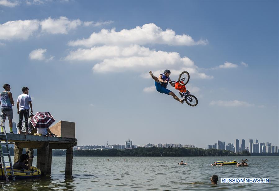 Фестиваль акробатических прыжков в озеро на велосипедах BMX прошел сегодня в кампусе Уханьского университета. 