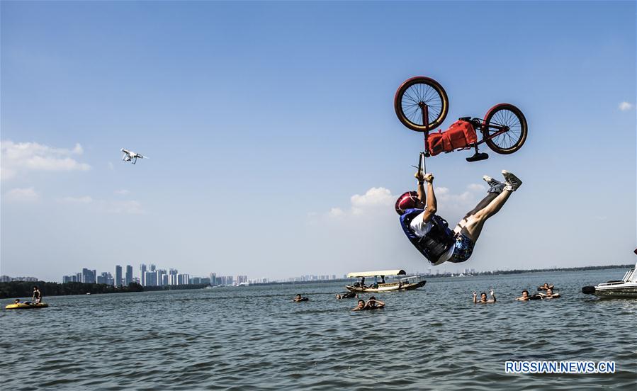 Почти 20 мастеров и любителей BMX со всего Китая поочередно заезжали на 50-метровую надводную эстакаду Линбомэнь, разгонялись и взлетали над озером Дунху, выделывая в полете всевозможные оригинальные фигуры, прежде чем упасть в воду.
