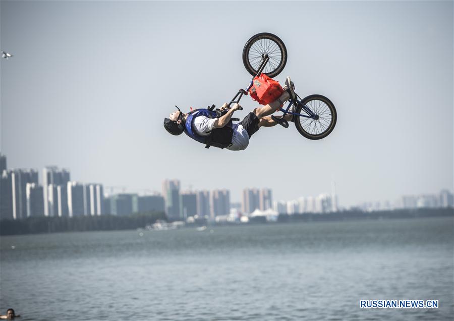 Фестиваль акробатических прыжков в озеро на велосипедах BMX прошел сегодня в кампусе Уханьского университета. 