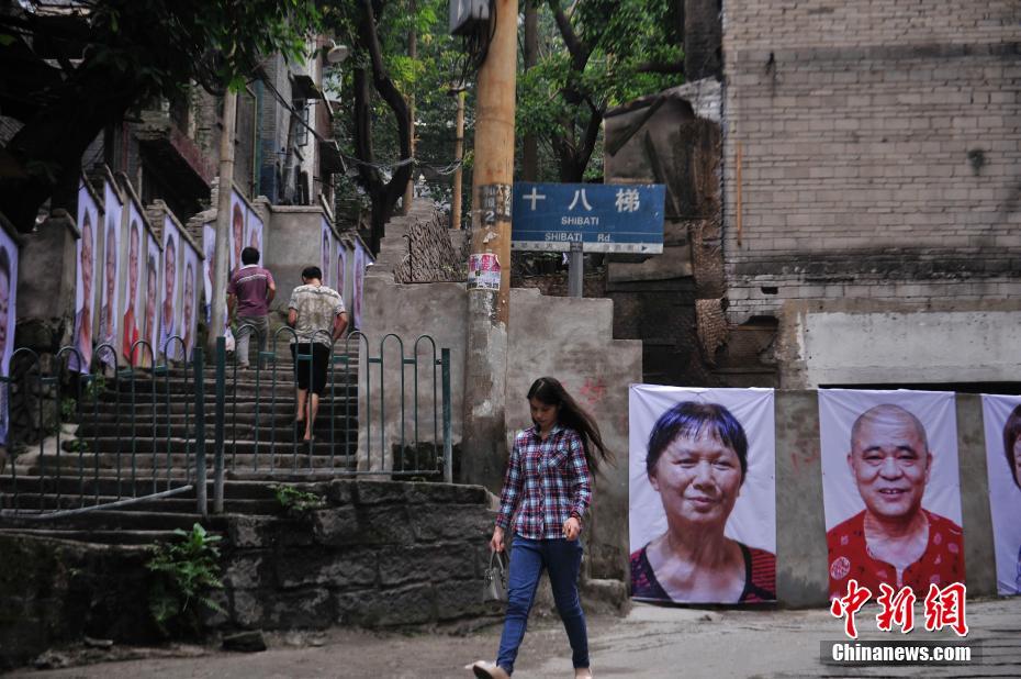 Фотопортреты переселенцев, развешенные на стенах «Восемнадцати лестниц» в Чунцине, привлекли внимание множества посетителей