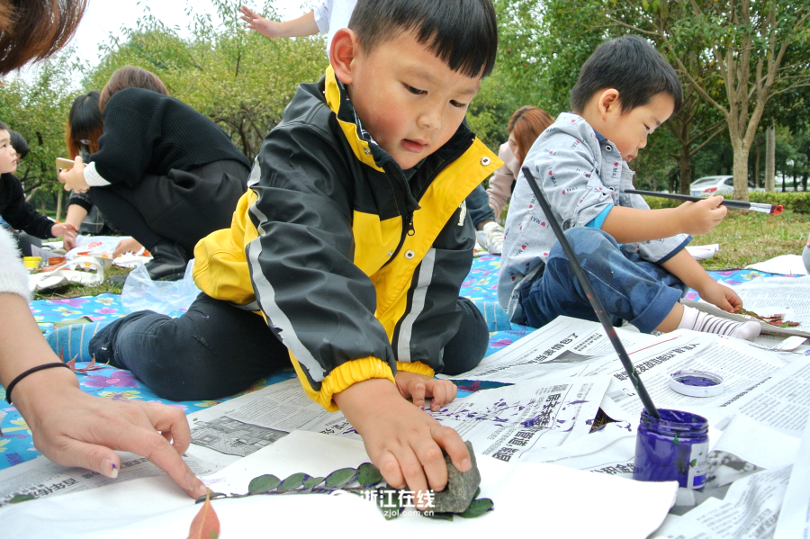 13 ноября, в центральном парке г. Цзясин, дети украшают холщовые сумки цветными орнаментами из листьев. 