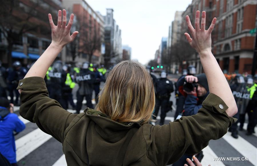 Примерно 500 одетых в черное протестующих прошли маршем по центру Вашингтона. В руках они держали плакаты, на одном из которых было написано 'Заставьте расистов снова бояться'.