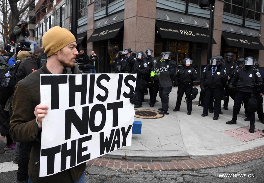 Примерно 500 одетых в черное протестующих прошли маршем по центру Вашингтона. В руках они держали плакаты, на одном из которых было написано 'Заставьте расистов снова бояться'.