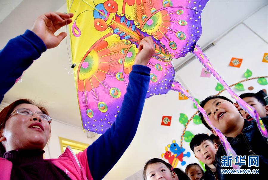 На фото: 20 февраля, учитель образцового детского сада уезда Юаньцюй провинции Шаньси на уроке показывает детям воздушного змея-бабочку.