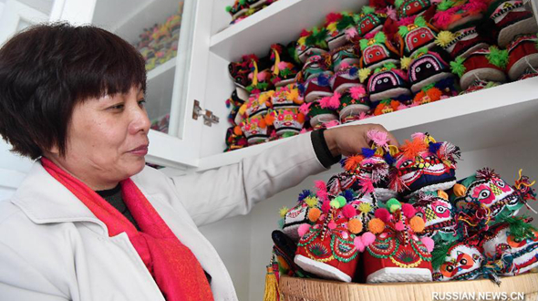 Китайская женщина коллекционирует 'тигриные' башмачки