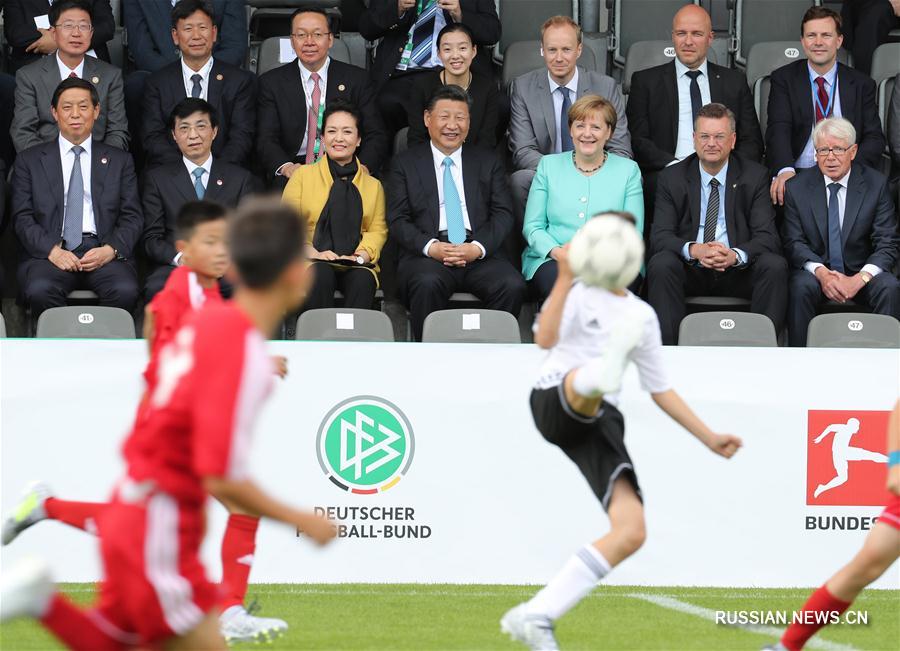 Си Цзиньпин с супругой Пэн Лиюань прибыли в Олимпиаштадион, где были встречены А. Меркель. 