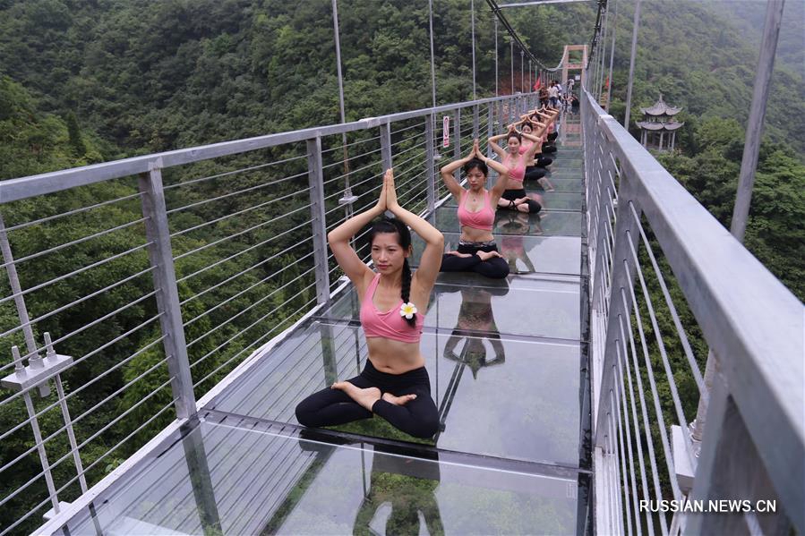 Йога на стеклянном висячем мосту в ландшафтном парке Тайцзися