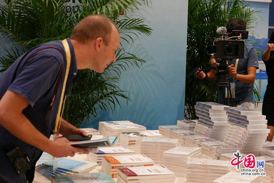 На фото: российский корреспондент посещает книжную выставочную зону внутри пресс-центра.