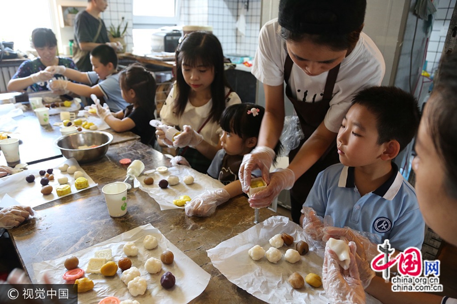 24 сентября, г. Цзинань, младшие школьники начальной школы при Шаньдунском педагогическом университете вместе со своими родителями делают «снежные» лунные пряники, знакомясь с традиционной китайской культурой. 