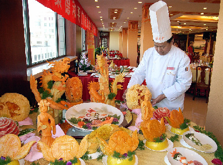 Un cocinero del restaurante de pato laqueado Quan Ju De, en Beijing, está arreglando los manjares para un grupo de clientes. En China es habitual que los amigos se reúnan en una tienda de comida para probar delicias.