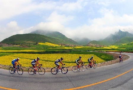 Ciclistas pugnando adelante en una carrera internacional de bicicletas por la carretera en la provincia de Qinghai, China.