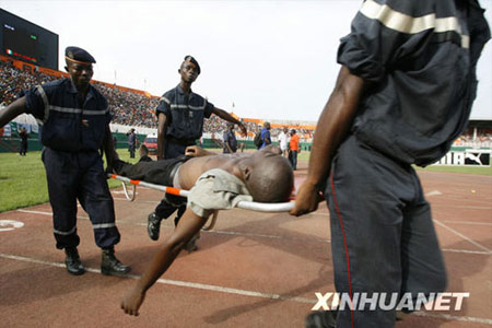 Firefighters carry a man injured in a stadium crush during the 2010 World Cup qualifying soccer match between Cote d'Ivoire and Malawi at Felix Houphouet-Boigny stadium in Abidjan March 29, 2009. 