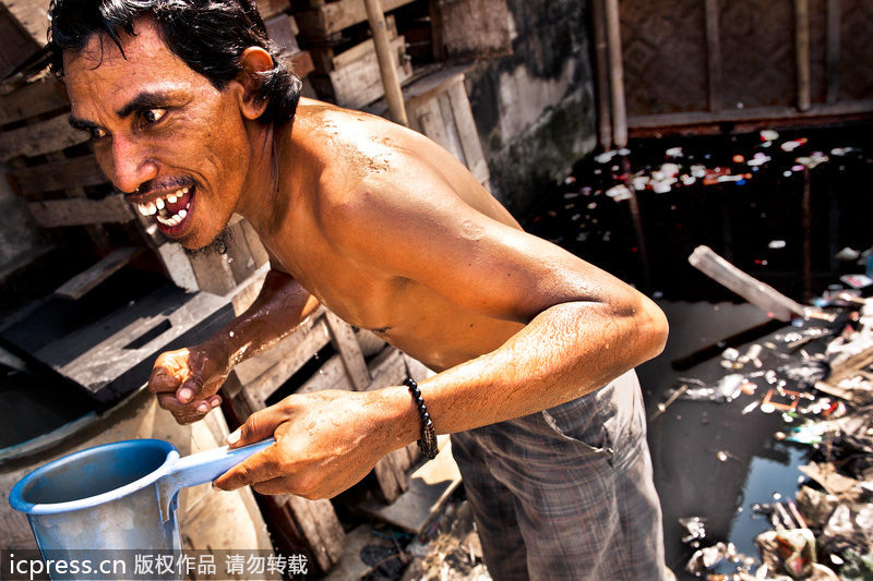 Un hombre se duchaba en el barrio bajo de Jacarita 一名男子在雅加达的贫民窟洗澡
