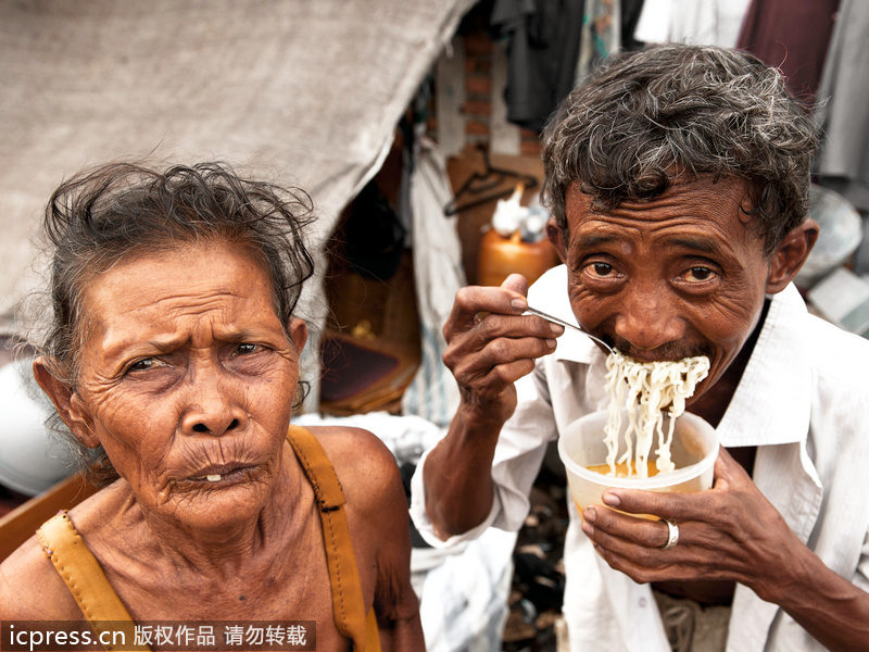 Dos ancianos estaban comiendo mientras miraban al lente. 兩名正在吃飯的老人不安的看著鏡頭。