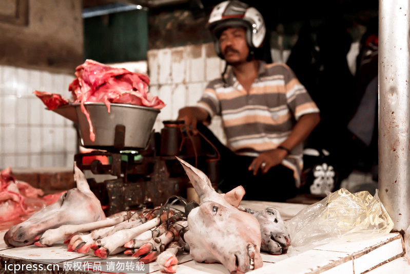 Un hombre vendía carne y la cabeza de oveja con un casco 一名男子戴著頭盔售賣肉和羊頭。