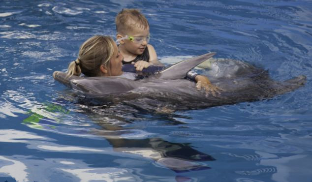 Niños de 8 años quien perdió las dos piernas nada con un delfin