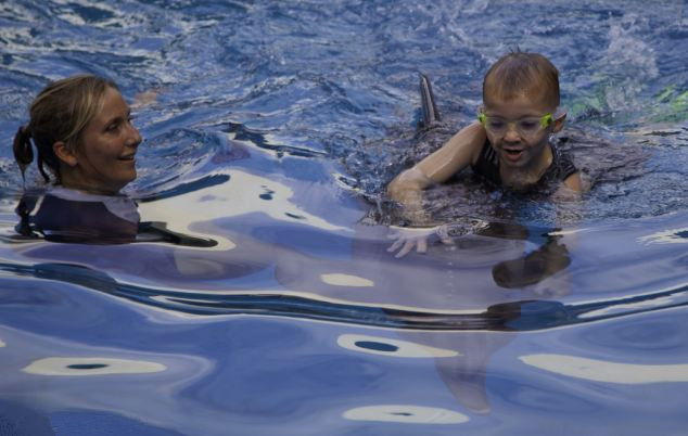 Niños de 8 años quien perdió las dos piernas nada con un delfin