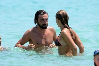 El futbolista italiano Andrea Pirlo se besa con su esposa en la playa