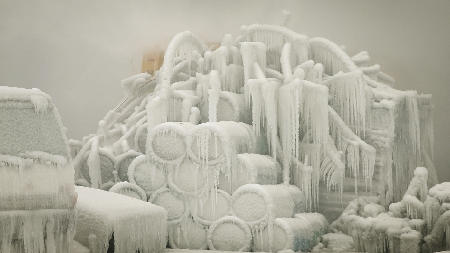23 de enero: Una camioneta está cubierta de hielo mientras bomberos tratan de extinguir un incendio masivo en Chicago. 