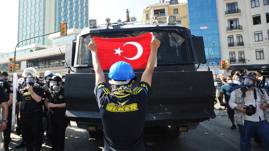 11 de junio: un manifestante levanta una bandera de Turquía para bloquear a la policía local que trataba de retomar el control de la plaza Taksim. 