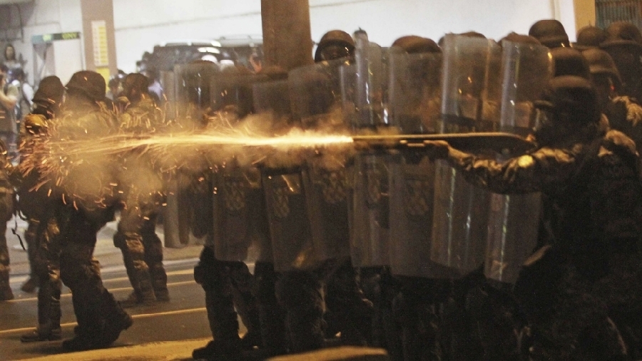 30 de junio: la policía de Rio de Janeiro trata de dispersar a los manifestantes apostados frente al Maracana, durante un juego entre México-Brasil.