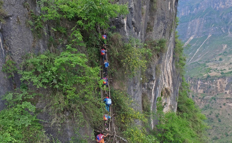 Unos niños escalan un acantilado de 800 metro en el camino a la escuela