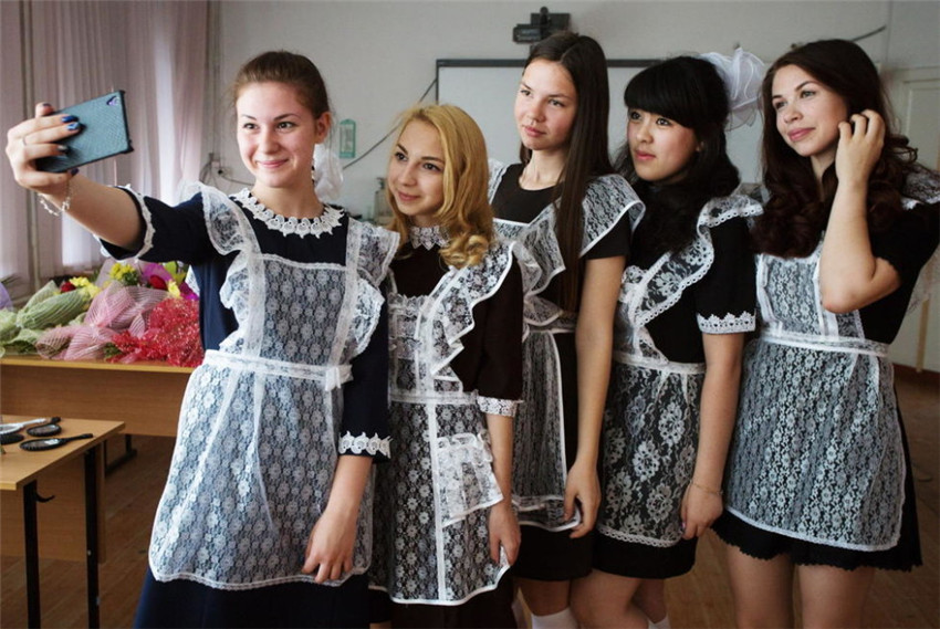 Chicas rusas toman fotos de graduación en uniformes de sirvienta