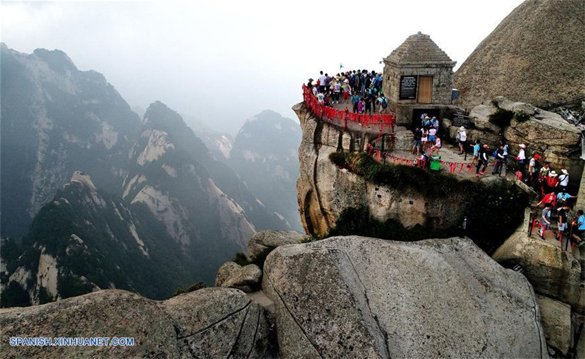 Turistas caminan sobre un camino de tablones construido sobre un acantilado, en la montaña Huashan en Huayin, provincia de Shaanxi, en el noroeste de China, el 14 de julio de 2017. La temporada alta comenzó en el área escénica cuando un gran número de turistas viene a visitar la montaña Huanshan en el verano. 