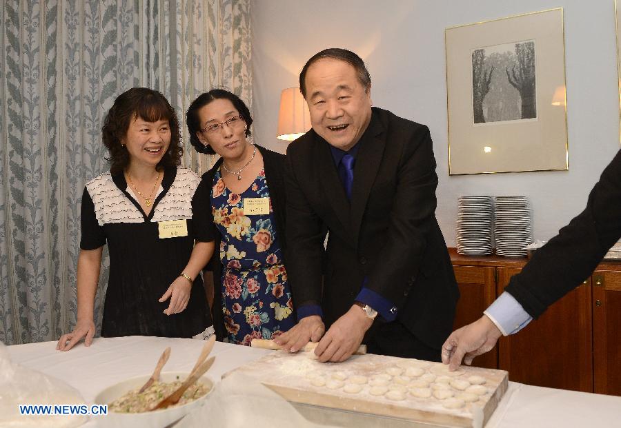 12月9日，在瑞典首都斯德哥尔摩，2012年诺贝尔文学奖得主、中国作家莫言（右）在当地华人华侨举办的欢迎宴会前与众人一起包饺子。[新华社]
