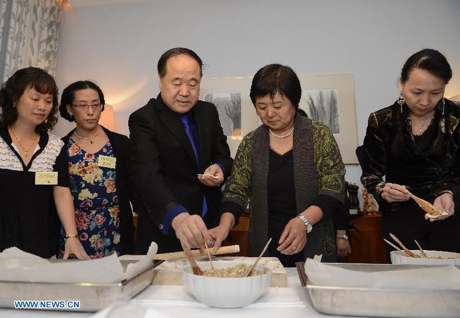 12月9日，在瑞典首都斯德哥尔摩，2012年诺贝尔文学奖得主、中国作家莫言（前左）与夫人杜勤兰（前右）在当地华人华侨举办的欢迎宴会前与众人一起包饺子。[新华社]