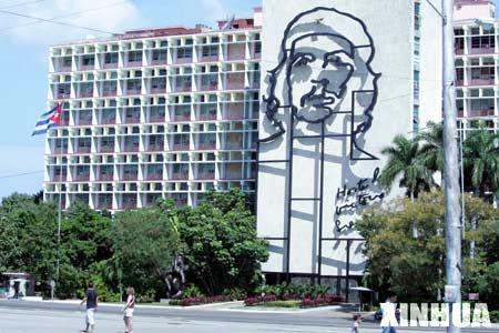 People walk past the building of Cuba’s Interior Ministry, which is decorated with a portrait of Che Guevara, in Havana, Cuba, Feb. 23, 2008. Cuba has completed all preparations for the elections of a new president and other national leaders, and the elections will proceed on Sunday as scheduled, President of the National Electoral Commission and Justice Minister Maria Esther Reus said on Saturday. The Cuban National Assembly of People's Power will be convened on Sunday, when the 614 deputies elected last month will be called to create the country's new legislature.(