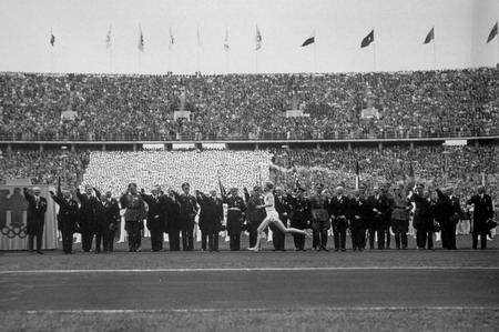 The Olympic torch is carried into the Berlin stadium, at the start of the 1936 Olympic Games.