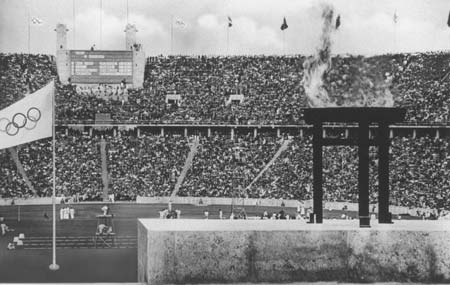 General view of the Olympic Stadium with the Olympic Flame burning in the foreground during athletics events at the 1936 Olympic Games in Berlin.