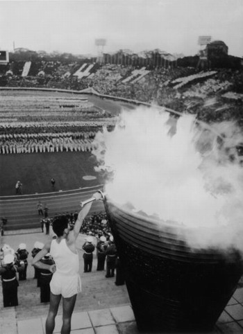 Yoshinori Sakai, who was born in Hiroshima on the day the first atomic bomb devastated the city, lights the Olympic Flame in Tokyo's main stadium during the opening ceremony of the Olympic Games, on October 10, 1964.