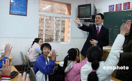 British Foreign Secretary David Miliband (Front) reacts with Chinese students in an English class in southwest China&apos;s Chongqing Municipality on Feb. 27, 2008.