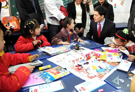 British Foreign Secretary David Miliband (R2) talks with a Chinese pupil in southwest China&apos;s Chongqing Municipality on Feb. 27, 2008.